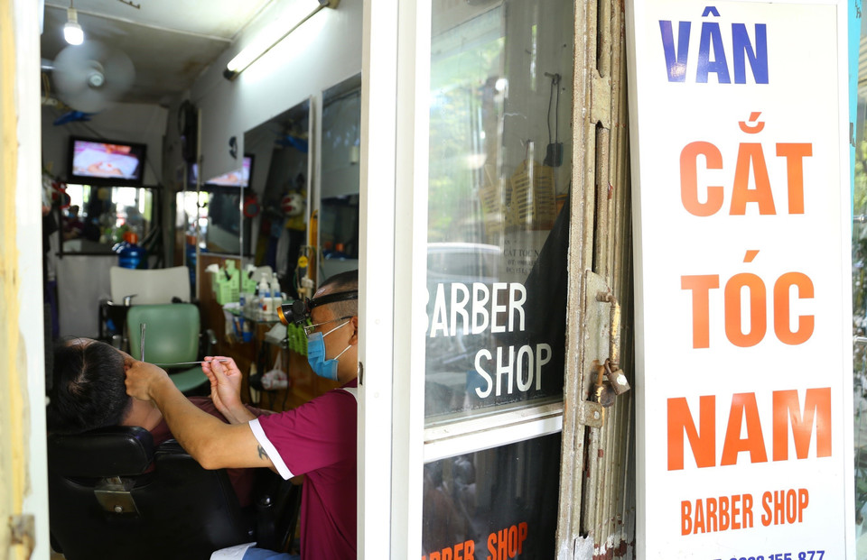 Một cửa hàng cắt tóc trên phố Lý Thái Tổ đã phục vụ khách hàng từ sáng 22/6. (Ảnh: Hoàng Hiếu/TTXVN)