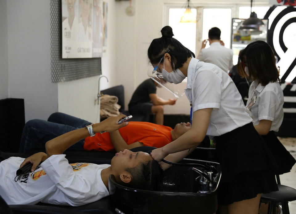 Một cửa hàng cắt tóc, gội đầu trên phố Lạc Trung đông khách trong ngày mở cửa trở lại. Ảnh: Hoàng Hiếu/TTXVN)