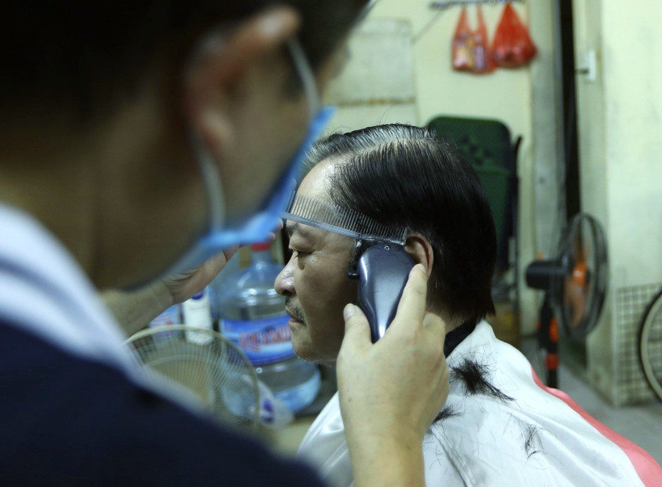 Một khách hàng 70 tuổi, cắt tóc sau gần 2 tháng. (Ảnh: Hoàng Hiếu/TTXVN)