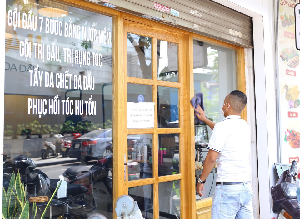 Một cửa hàng trên phố Hàng Tre được lau dọn trước khi đón khách sáng 22/6. (Ảnh: Hoàng Hiếu/TTXVN)