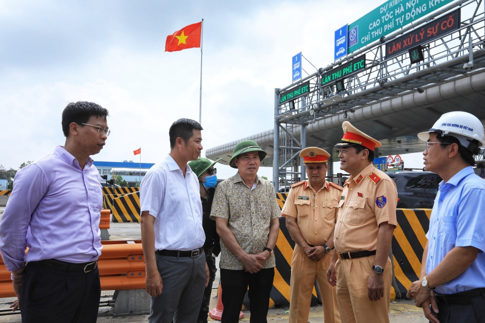 Tổng cục trưởng Tổng cục Đường bộ Việt Nam Nguyễn Văn Huyện (thứ tư từ phải sang) trao đổi với các đơn vị thực hiện trong ngày đầu thực hiện thí điểm trên tuyến đường cao tốc Hà Nội-Hải Phòng. (Ảnh: Tuấn Anh/TTXVN)
