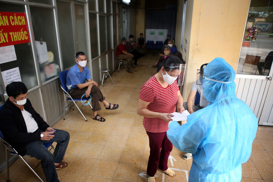  Trả kết quả xét nghiệm nhanh COVID-19 cho các tiểu thương kinh doanh tại chợ đầu mối hoa quả Hoàng Mai, sáng 18/4. (Ảnh: Danh Lam/TTXVN)