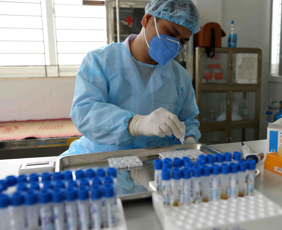 Nhân viên CDC Hà Nội làm xét nghiệm nhanh COVID-19 cho người dân xã Lê Lợi và tiểu thương kinh doanh tại chợ đầu mối gia cầm Hà Vĩ (huyện Thường Tín), sáng 18/4. (Ảnh: Vũ Sinh/TTXVN)