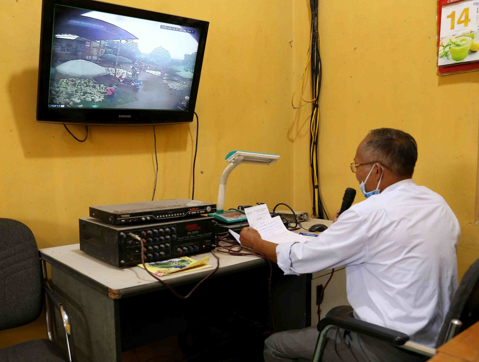 Ban Quản lý chợ đầu mối gia cầm Hà Vĩ (huyện Thường Tín) tuyên truyền, vận động người dân kinh doanh tại chợ tham gia lấy mẫu máu xét nghiệm nhanh COVID-19 qua hệ thống loa phát thanh, sáng 18/4. (Ảnh: Vũ Sinh/TTXVN)