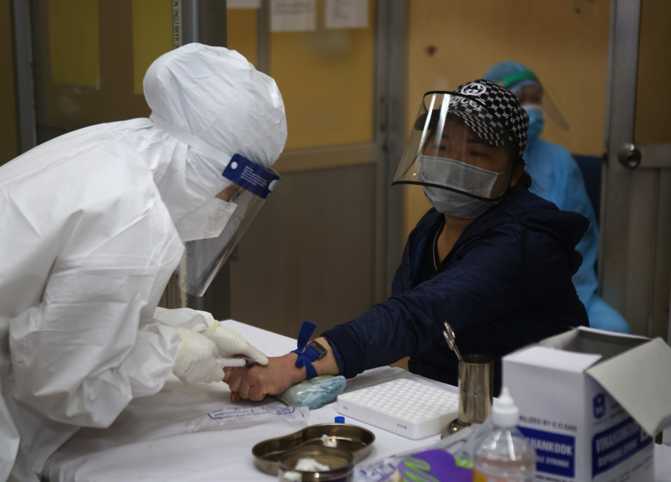  Lấy mẫu máu để xét nghiệm nhanh COVID-19 cho các tiểu thương kinh doanh tại chợ đầu mối hoa quả Hoàng Mai, sáng 18/4. (Ảnh: Danh Lam/TTXVN)