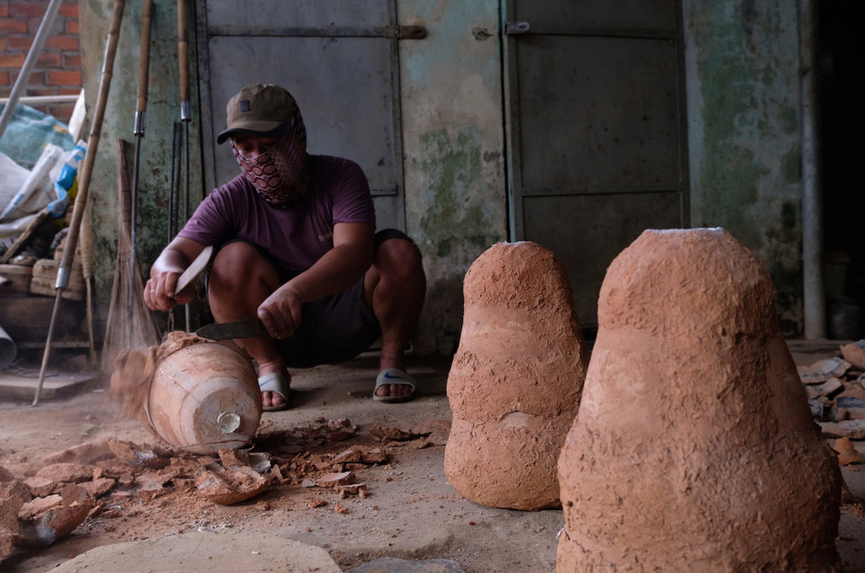 Sau khi đổ vào khuôn đúc khoảng 30 phút, đồng sẽ đông cứng và được đập bỏ khuôn bằng đất. (Ảnh: Nguyễn Dũng/TTXVN)