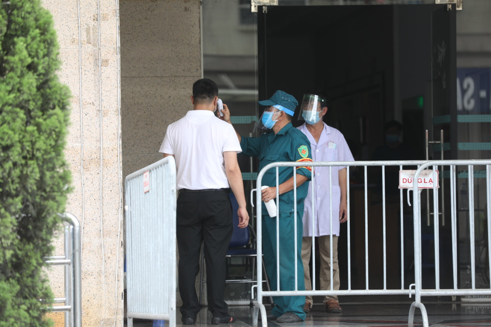 Cư dân trở về nhà tại Tòa N03A khu đô thị mới Sài Đồng, quận Long Biên phải khai báo y tế và kiểm tra thân nhiệt. (Ảnh: Minh Quyết/TTXVN)