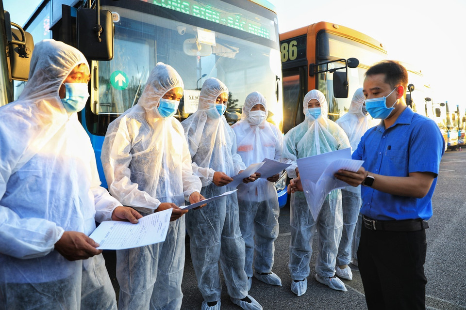 Các tài xế mỗi xe nhận danh sách các lao động từ Bắc Giang về theo mỗi quận, huyện. (Ảnh: Thành Đạt/TTXVN)