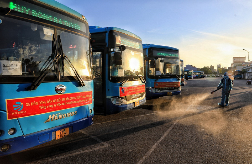 Phun khử khuẩn toàn bộ đoàn xe buýt trước khi lên đường đón 286 công dân từ Bắc Giang về. (Ảnh: Thành Đạt/TTXVN)