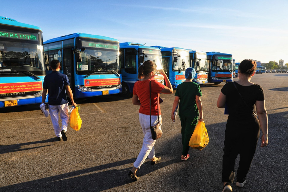 Lực lượng y tế chuẩn bị lên xe đi đón người dân từ thị trấn Nếnh (huyện Việt Yên, tỉnh Bắc Giang) về trung tâm y tế các quận, huyện, thị xã trên địa bàn Hà Nội. (Ảnh: Thành Đạt/TTXVN)