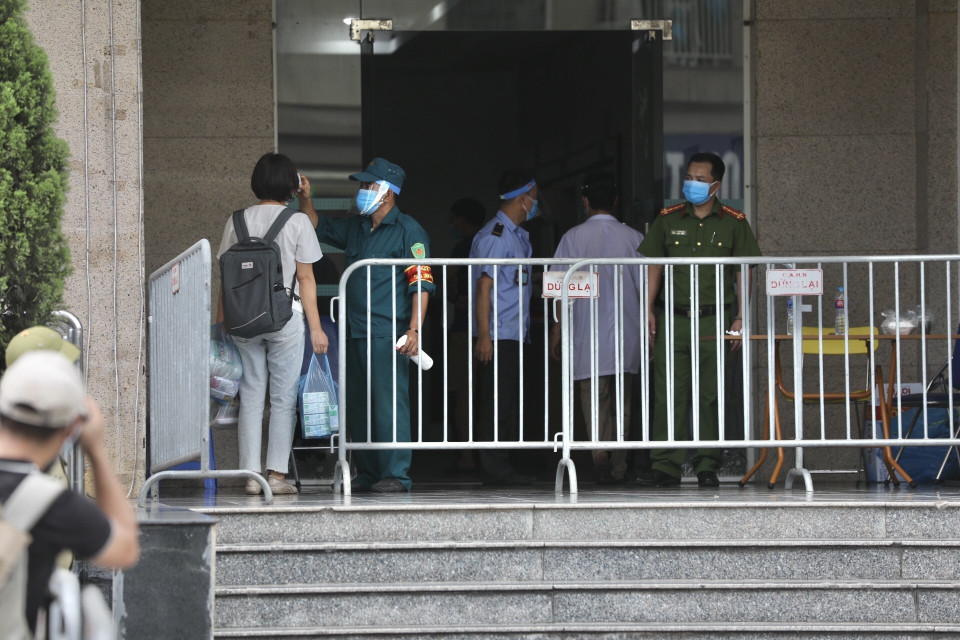 Cư dân trở về nhà tại Tòa N03A khu đô thị mới Sài Đồng, quận Long Biên phải khai báo y tế và kiểm tra thân nhiệt. (Ảnh: Minh Quyết/TTXVN)