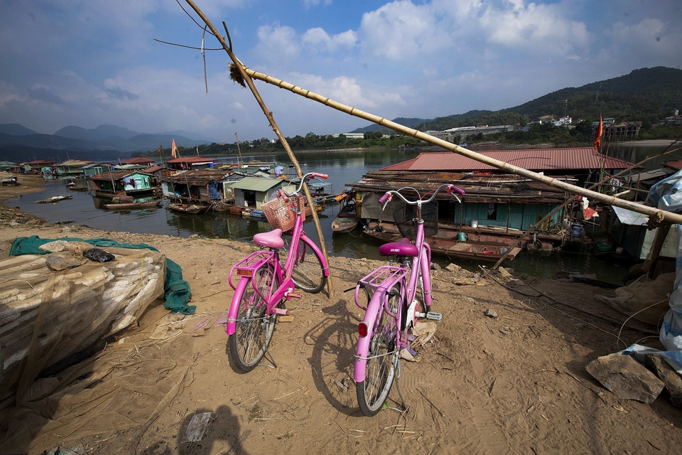 Những chiếc xe đạp xinh của những bé gái để lại trên đê sau buổi học về lại làng vạn chài. (Ảnh: Trọng Đạt/TTXVN)