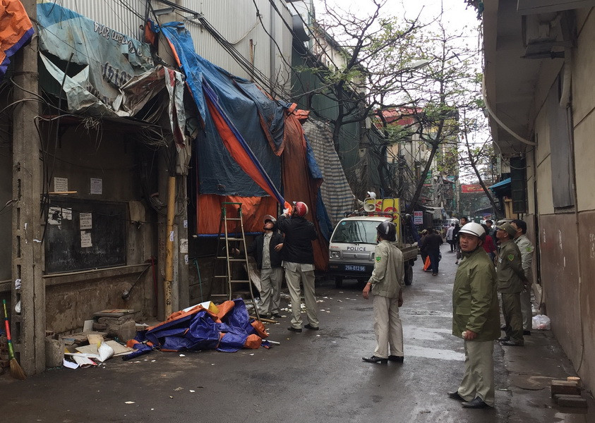 Cán bộ công an, dân phòng, thanh tra xây dựng phường Phú Diễn (quận Bắc Từ Liêm) ra quân xử lý vi phạm lấn chiếm vỉa hè. (Ảnh: Nguyễn Thắng/TTXVN)