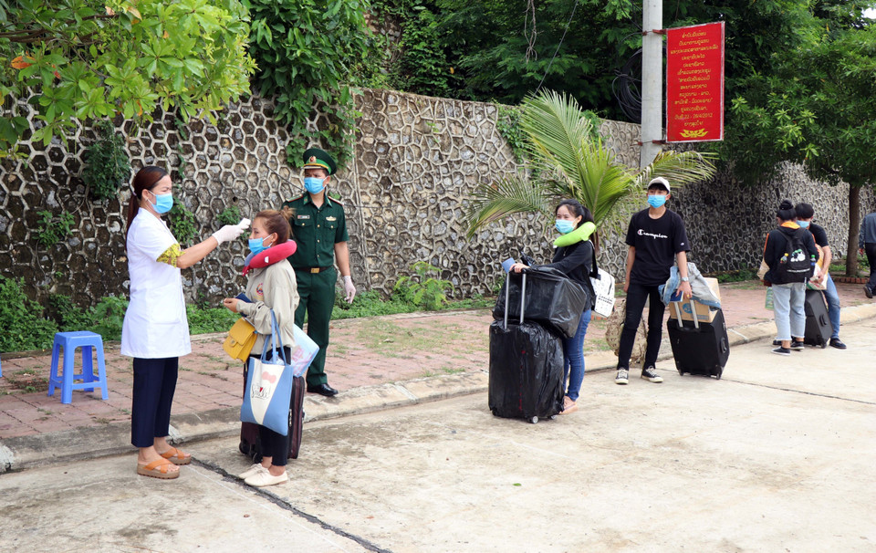 Các lưu học sinh Lào được kiểm tra thân nhiệt trước khi nhập cảnh tại cửa khẩu Chiềng Khương, tỉnh Sơn La. (Ảnh: Hữu Quyết/TTXVN)