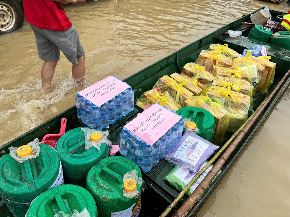 Thuyền đưa thức ăn, nước uống cứu trợ đến người dân. (Ảnh: TTXVN phát)