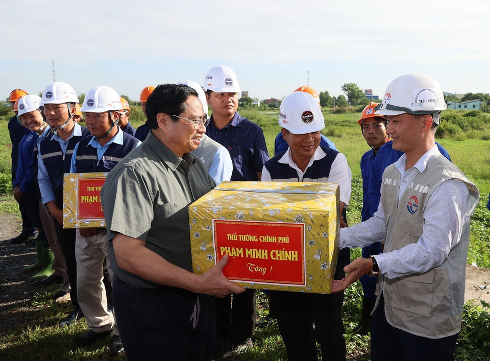Thủ tướng Phạm Minh Chính tặng quà cho công nhân thi công đường Vành đai 3 Thành phố Hồ Chí Minh đoạn qua tỉnh Long An. (Ảnh: Dương Giang/TTXVN)