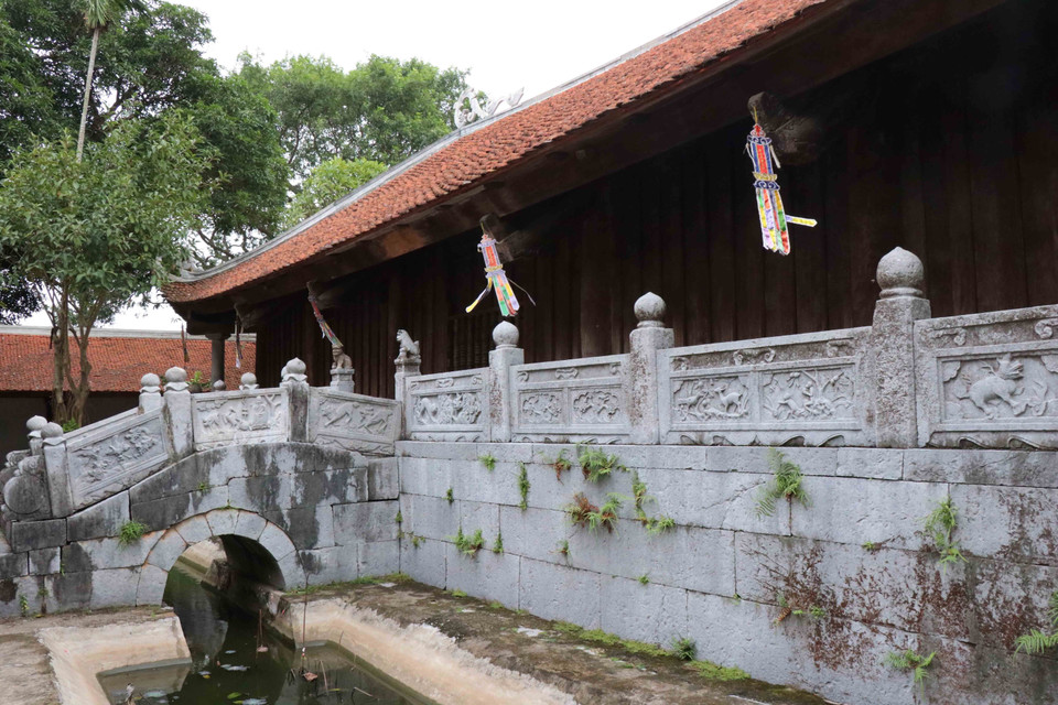 Cầu đá nối giữa Thượng Điện và tòa Tích Thiện Am bắc ngang hồ sen dài 4m gồm 3 nhịp uốn cong vồng. Mặt cầu lát đá xanh, hai bên cầu có 12 bức phù điêu đá chạm chim muông, hoa lá công phu, tinh xảo. (Ảnh: Thanh Thương/TTXVN)