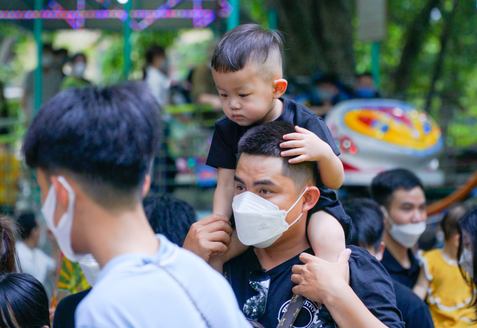 Nhiều ông bố phải cõng con trên vai để tránh dòng người đông đúc. (Ảnh: Minh Hiếu/Vietnam+)