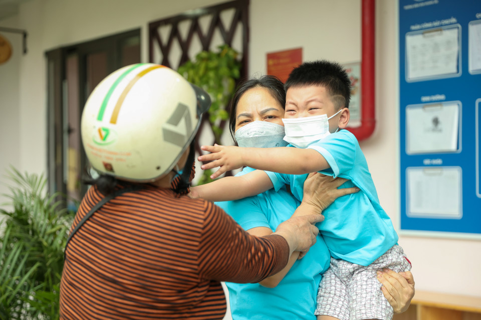 Bà Quách Thị Khanh (phường Hoàng Liệt) đưa em Phạm Quang Khải (4 tuổi) đến trường. Hôm nay là ngày đầu đi học lại nên Khải vẫn còn 'quyến luyến' bà. (Ảnh: Minh Hiếu/Vietnam+)