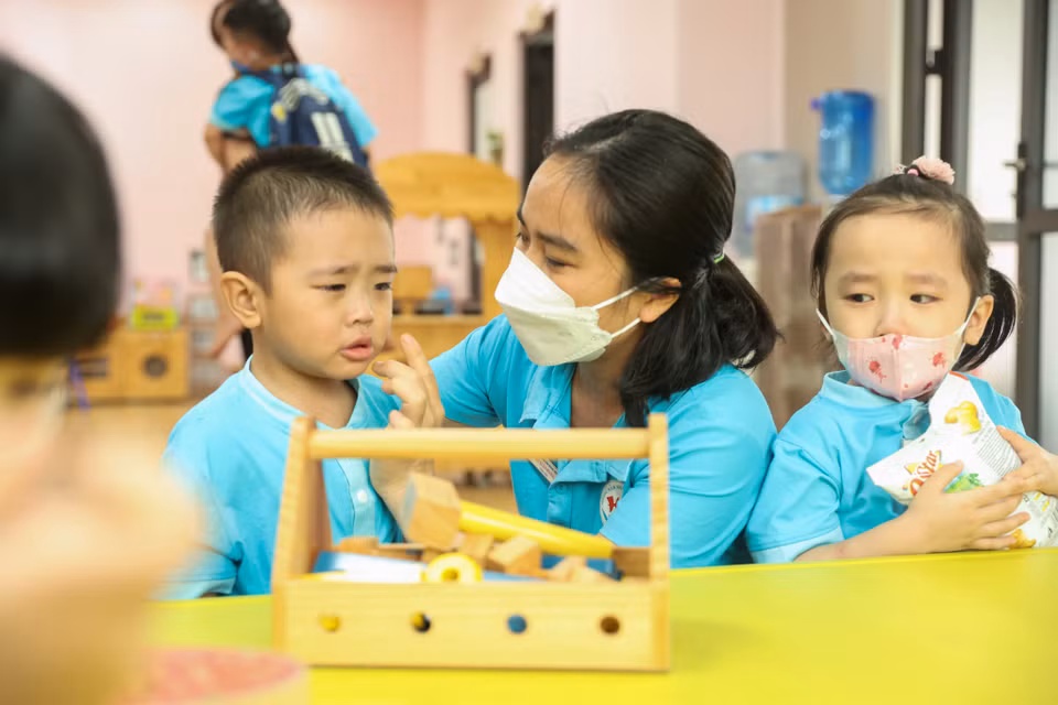 Một số em học sinh chưa quen với trường lớp cũng được các cô giáo từ tốn dỗ dành, động viên. (Ảnh: Minh Hiếu/Vietnam+)