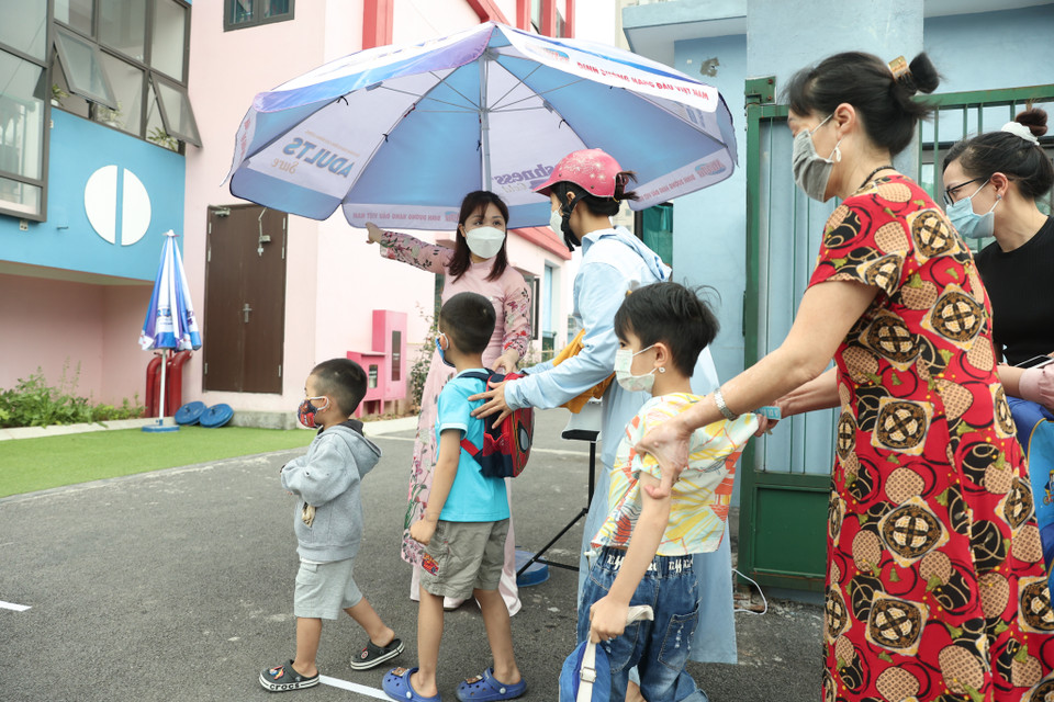 Các cô giáo phân làn, hướng dẫn phụ huynh và học sinh vào trong trường học. (Ảnh: Minh Hiếu/Vietnam+)