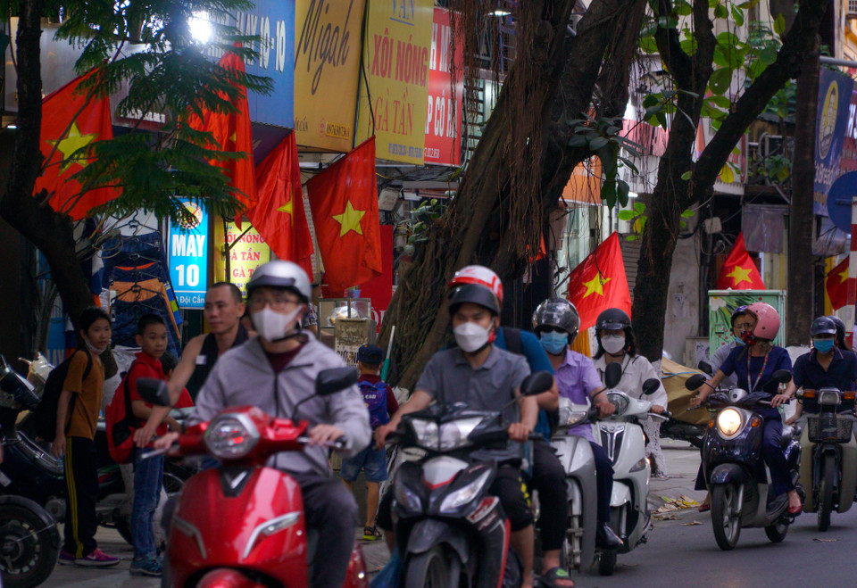 Không khó để bắt gặp hình ảnh cờ đỏ sao vàng trên trên khắp các tuyến phố, phường Hà Nội. (Ảnh: Minh Hiếu/Vietnam+) 