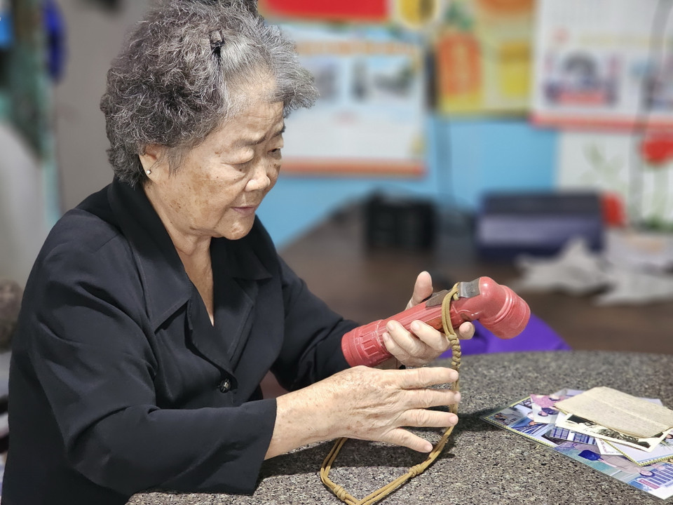 Bà Nguyễn Thị Bé với vật dụng là chiếc đèn pin - xưa cùng bà trực tiếp chỉ huy đội quân đắp đường tỉnh 49 - nay là quốc lộ 62. (Ảnh: Đức Hạnh/TTXVN)