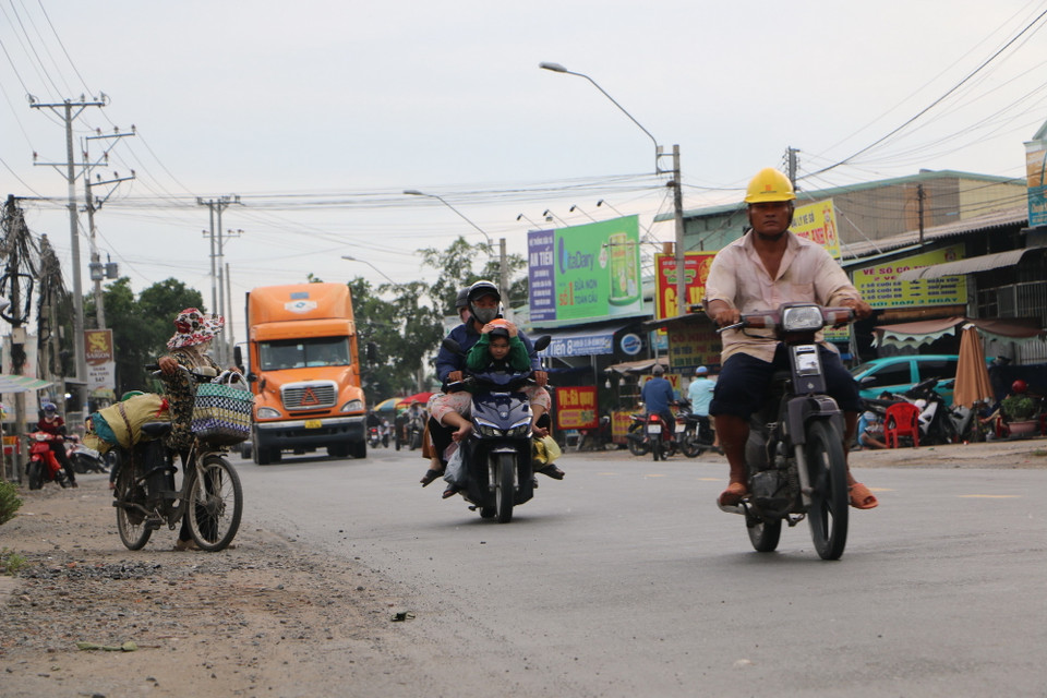 Mặt đường quốc lộ 62 hiện tại chỉ rộng 7m, nhưng lưu lượng giao thông cao và có nhiều đoạn đi qua khu dân cư ở 2 bên đường. (Ảnh: Đức Hạnh/TTXVN)