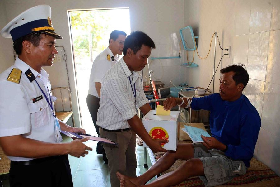 Một ngư dân tỉnh Bình Thuận đánh bắt cá trên biển bị nạn đang được điều trị tại Bệnh xá xã đảo Song Tử Tây thực hiện quyền công dân. (Ảnh: Trần Lê Lâm​/TTXVN) 