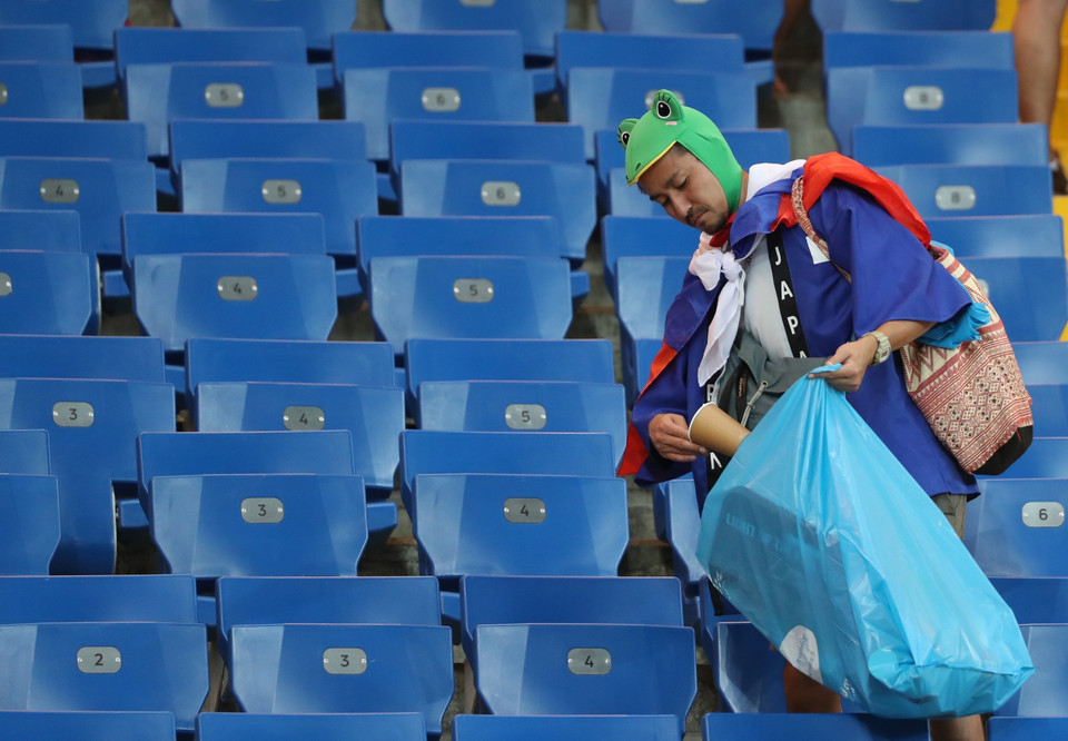 Tất cả cần mẫn nhặt từng mẩu rác còn sót lại trên khán đài (Ảnh: THX/TTXVN)