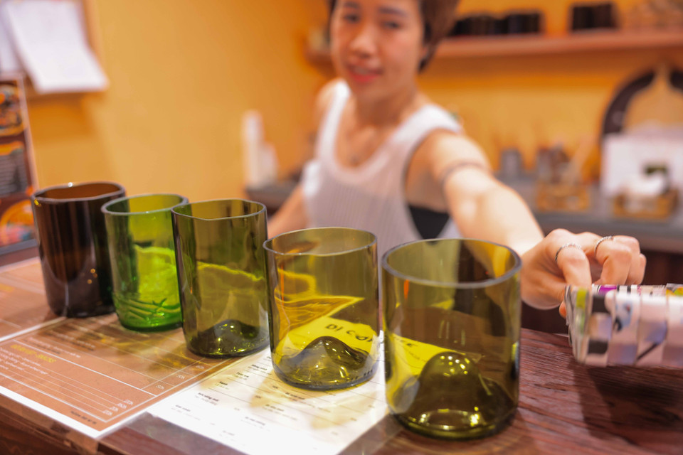 Những chiếc cốc được làm từ những vỏ chai rượu vang cũ được sử dụng tại quán càphê trên phố Tây Sơn. (Ảnh: Hoàng Hiếu/TTXVN)
