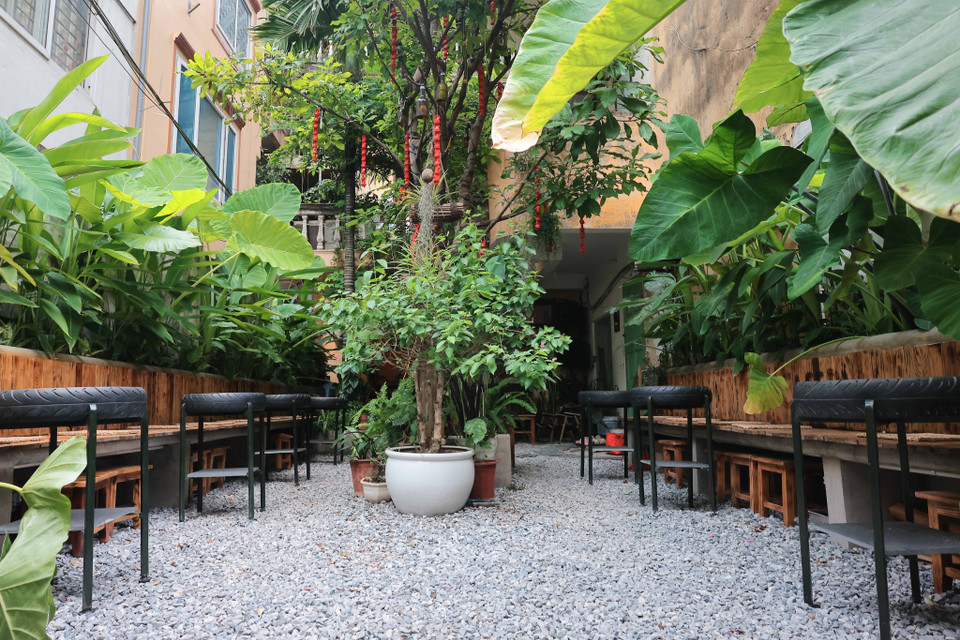 Không gian xanh của cây cối, với bàn ghế làm từ vật liệu tái chế tại một quán càphê trên phố Tây Sơn. (Ảnh: Hoàng Hiếu/TTXVN)