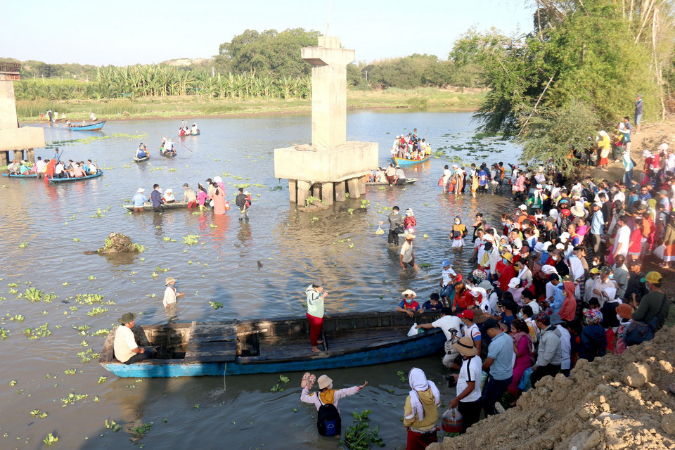 Người dân đi đò qua sông Lũy để đến khu nghĩa trang của người Chăm. (Ảnh: Nguyễn Thanh/TTXVN)