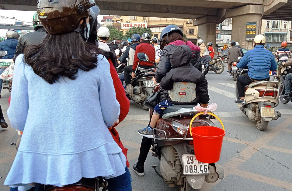 Nhiều người đã sử dụng xô chậu đựng cá chép để tiện cho việc phóng sinh, cũng như giảm phát thải túi nilon ra môi trường. (Ảnh: Hùng Võ/Vietnam+)