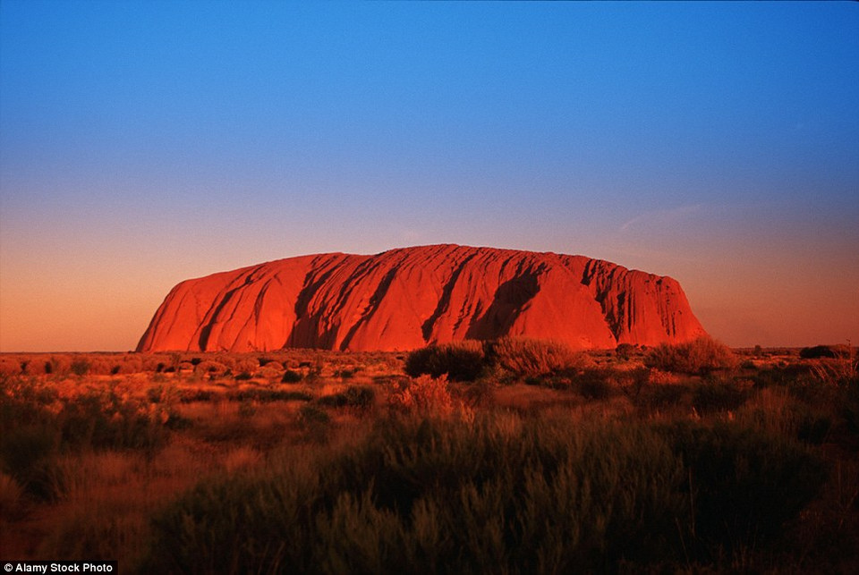 Trong ráng chiều, khối sa thạch màu nâm ở Ayers Rock ở Australia trở nên đỏ rực. (Nguồn: Getty Images)