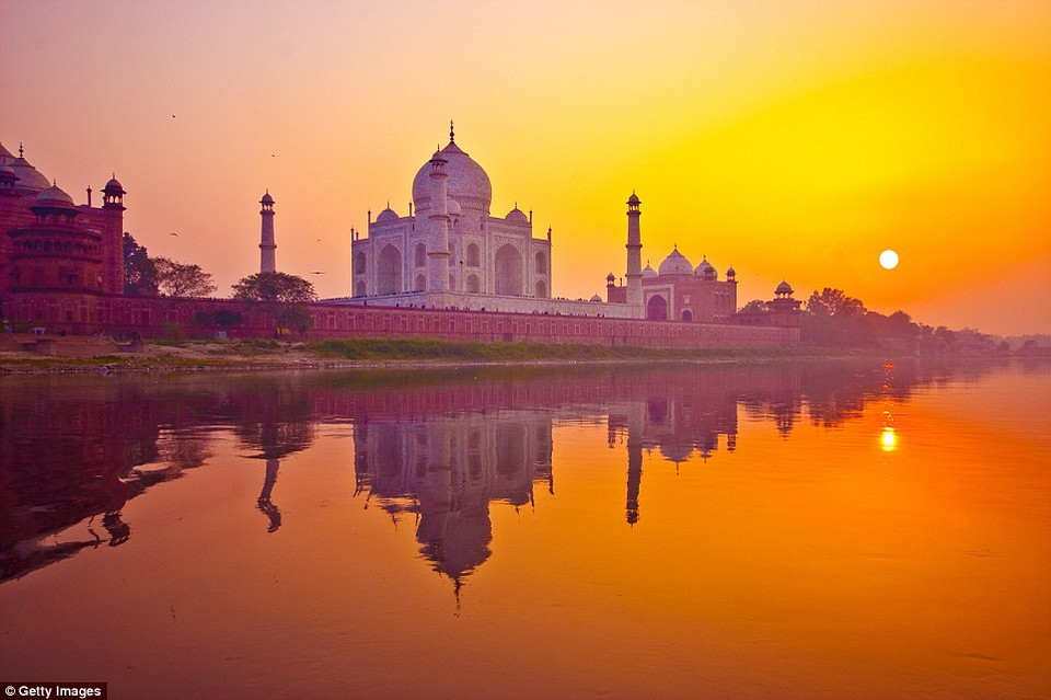 Khi mặt trời chìm dần phía sau Taj Mahal của Ấn Độ, ánh hoàng hôn khiến những bức tường bằng đá cẩm thạch trắng chuyển sang màu tím và hồ nước nhuộm màu da cam. (Nguồn: Getty Images)