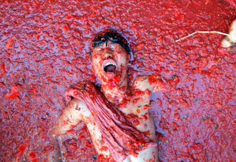 Một người đàn ông nằm trong vũng nước cà chua trong khuôn khổ lễ hội cà chua hàng năm “Tomatina”. Đường phố tại thị trấn miền đông Tây Ban Nha Bunola tràn ngập một màu đỏ, khi có khoảng 22.000 người sử dụng tổng cộng 125 tấn cà chua chín để “tấn công” lẫn nhau.