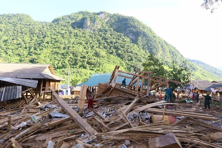 Lực lượng công an và bộ đội địa phương đang huy động hết lực lượng giúp người dân bản Poọng dựng nhà sớm ổn định cuộc sống, sinh hoạt. (Ảnh: Quyết Đạt/TTXVN)