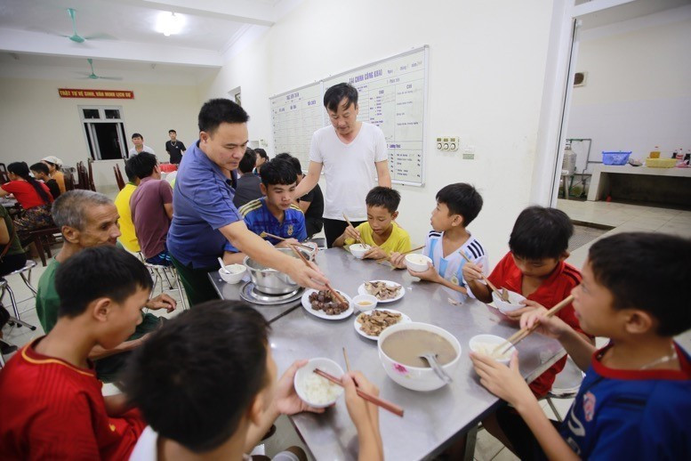 Cán bộ, chiến sỹ Đồn biên phòng Tam Chung ân cần chăm lo bữa ăn tối của người dân Bản Poọng đang tạm trú tại đơn vị. (Ảnh: Quyết Đạt/TTXVN)