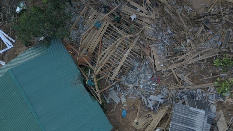 Lực lượng Công an và Bộ đội địa phương đang huy động hết lực lượng giúp người dân bản Poọng dựng nhà, sớm ổn định cuộc sống và sinh hoạt. (Ảnh: Quyết Đạt/TTXVN)