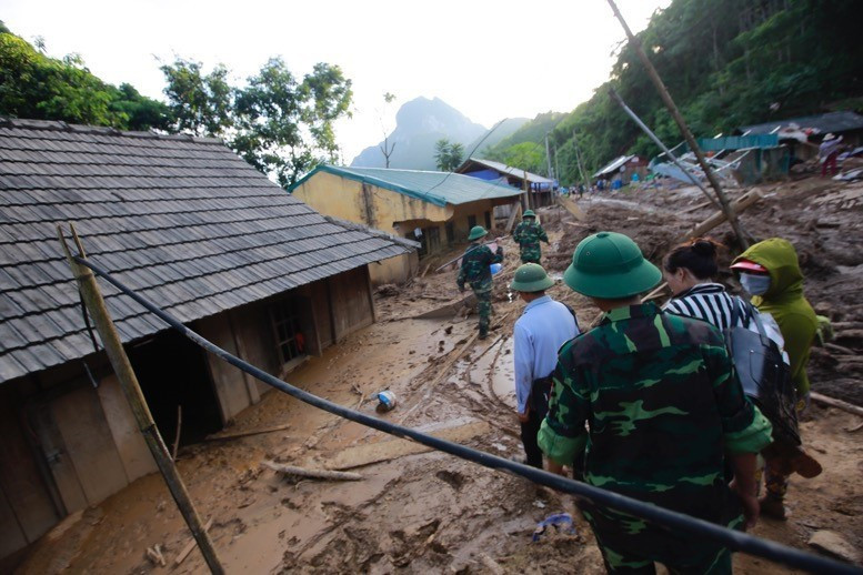 Lực lượng công an và bộ đội địa phương đang huy động hết lực lượng giúp người dân bản Poọng mở đường, dựng nhà, sớm ổn định cuộc sống. (Ảnh: Quyết Đạt/TTXVN)