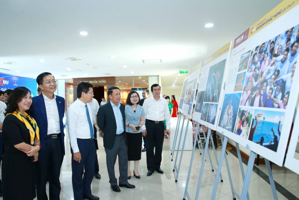 Đại biểu tham quan trưng bày các tác phẩm xuất sắc tham dự Giải ảnh báo chí 'Khoảnh khắc Vàng' lần thứ 6. (Ảnh: Phương Hoa/TTXVN)