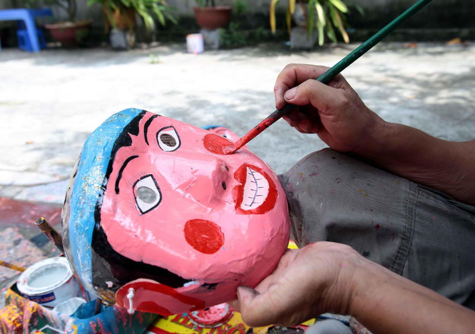 Mặt nạ được những nghệ nhân tỉ mẩn vẽ mô phỏng lại các nhân vật dân gian. (Ảnh: Phạm Kiên/TTXVN)