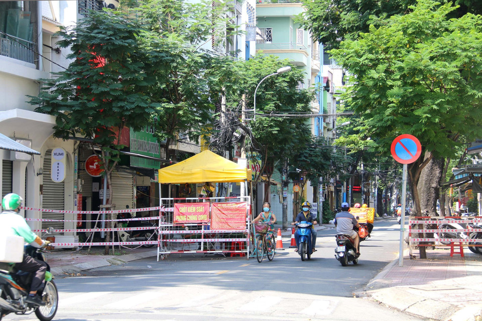 Đông đúc người xe lưu thông qua chốt gác trên đường Bà Hạt, Quận 10, TP Hồ Chí Minh không kiểm soát. (Ảnh: Thanh Vũ/TTXVN)