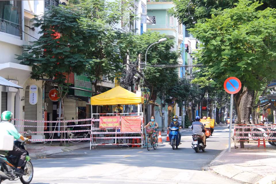 Đông đúc người xe lưu thông qua chốt gác trên đường Bà Hạt, Quận 10, TP Hồ Chí Minh không kiểm soát. (Ảnh: Thanh Vũ/TTXVN)