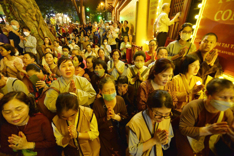 Phật tử tới chùa Quán Sứ nguyện cầu quốc thái dân an, thế giới hòa bình, chúng sinh an lạc. (Ảnh: Minh Đức/TTXVN)