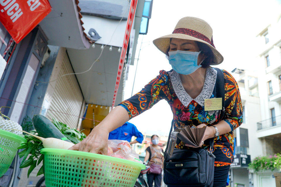 'Sản phẩm tươi sống như thịt, cá, tôm đều được bảo quản nên vẫn giữ được độ tươi ngon và đảm bảo các dưỡng chất. Hầu hết mọi người đều có ý thức chấp hành tốt quy định phòng dịch để tự bảo vệ sức khỏe cho chính mình và cộng đồng nên tôi cảm thấy khá an tâm khi mua sắm ở đây,' cô Tuyết, một người dân cho hay. (Ảnh: Minh Hiếu/Vietnam+)