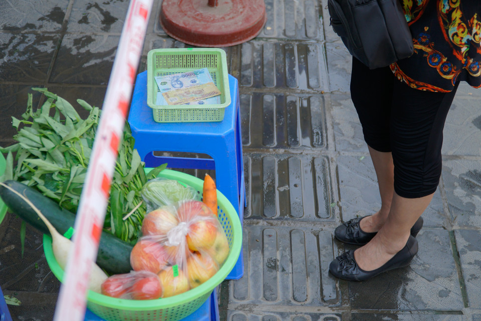 Đồ ăn và tiền thanh toán sẽ được để vào khay riêng, tránh việc tiếp xúc nhất có thể. (Ảnh: Minh Hiếu/Vietnam+)