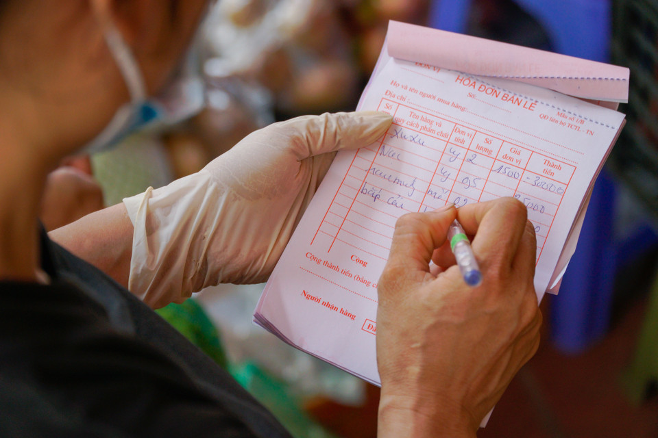 Ngoài việc đi mua trực tiếp, người dân có thể chọn lên nhóm Zalo của từng tổ dân phố để đặt hàng, sau đó lực lượng tại điểm bán hàng lên đơn, hỗ trợ mang đến tận nơi. (Ảnh: Minh Hiếu/Vietnam+)