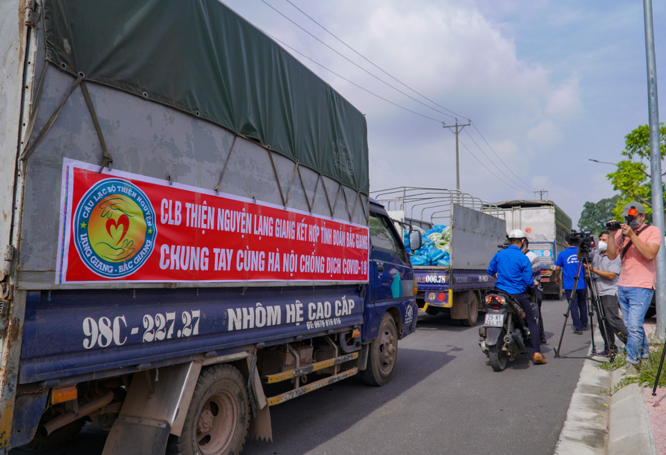 Rất nhiều xe tải chứa ắp hàng hóa đã được vận chuyển tới khu vực nút giao Phù Đổng (xã Phù Động, huyện Gia Lâm) để trao cho Thành đoàn Hà Nội điều phối. (Ảnh: Minh Hiếu/Vietnam+)